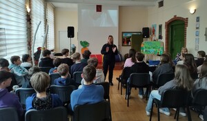 policjantka prowadzi spotkanie w tle uczniowie i sala