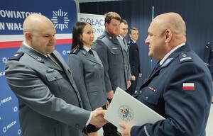 Komendant wręcza awanse w tle sala