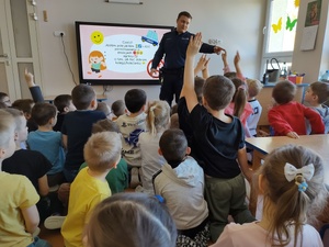 policjant rozmawia z dziećmi w tle wyposażenie sali