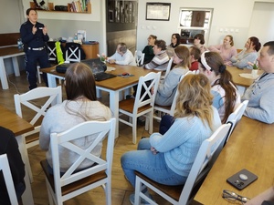 policjantka prowadzi spotkanie w tle ekran i wyposażenie sali