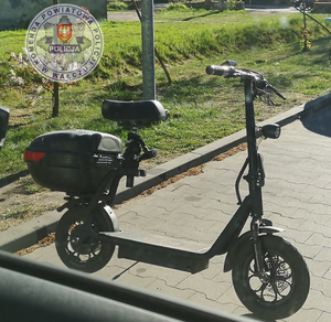 motorower przypominający hulajnogę w tle zieleń
