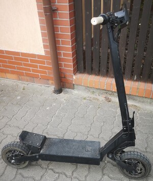 hulajnoga elektryczna w tle drewniane ogrodzenie