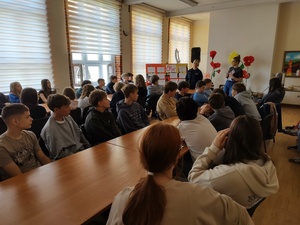 goście prowadzą spotkanie, w tle sala