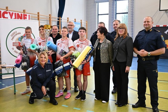 Zwycięzcy z pucharami, nagrodami w tle sala gimnastyczna