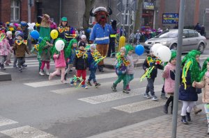 Przedszkolaki i policjanci wracają do placówki w tle miasto