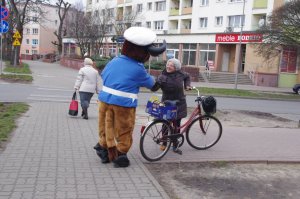 Kobieta wita się z maskotą, w tle rower