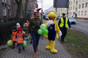 Spacer chodnikiem z policjantami w tle pojazdy