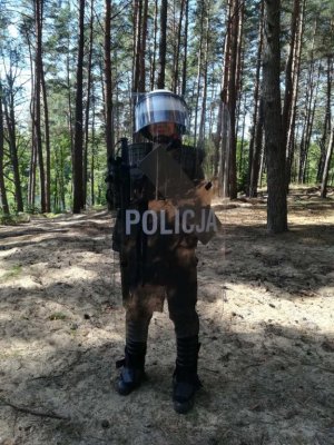 policjantka trzyma a tarczę, w tle las