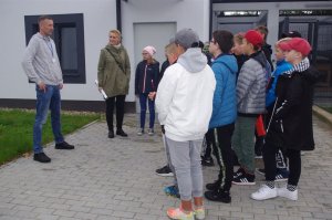uczniowie wsłuchani w rozmowę przewodnika psa, w tle kojce