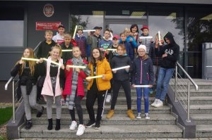 wspólne zdjęcie na schodach budynku komendy, w tle drzwi wejściowe i tablica informacyjna