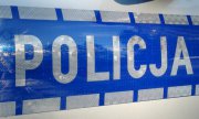 napis Policja na drzwiach radiowozu, na niebieskim pasie srebrne drukowane litery napisu