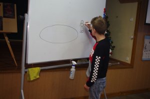 uczeń rysuje zagadkę, w tle sala