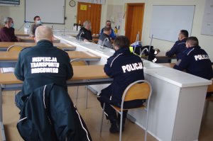 policjanci i przewoźnicy w klasie szkolnej w tle sala