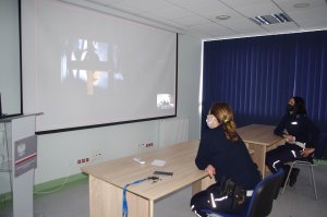 policjantki wspólnie z uczniami oglądają spot, w tle ekran i film