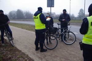policjanci rozmawiają z rowerzystami, w tle ścieżka rowerowa
