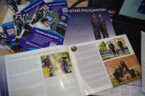 broszury, ulotki o zawodzie policjanta, w tle blat biurka